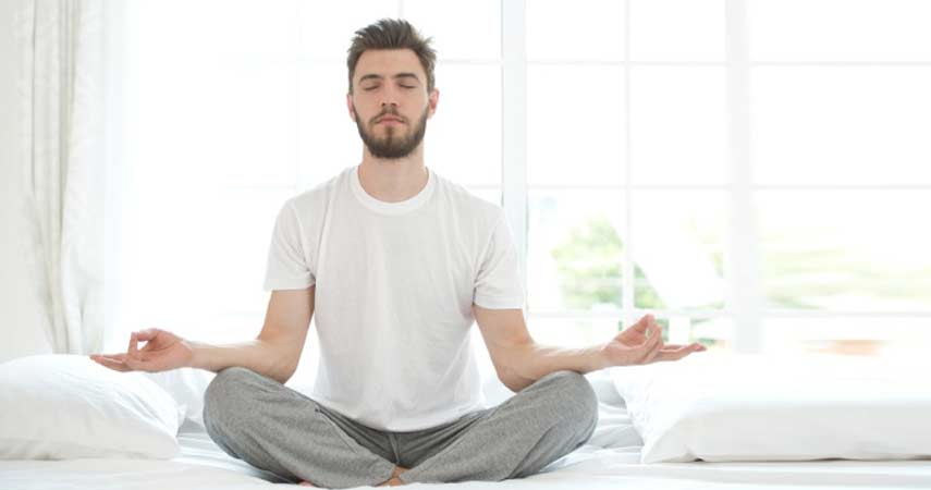 Young Man Meditating Bedroom